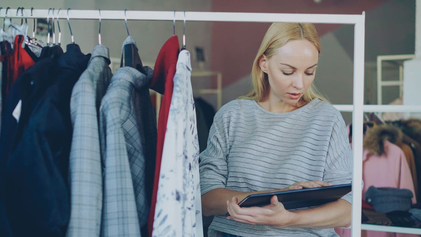 Retail employee using a tablet in a clothing store